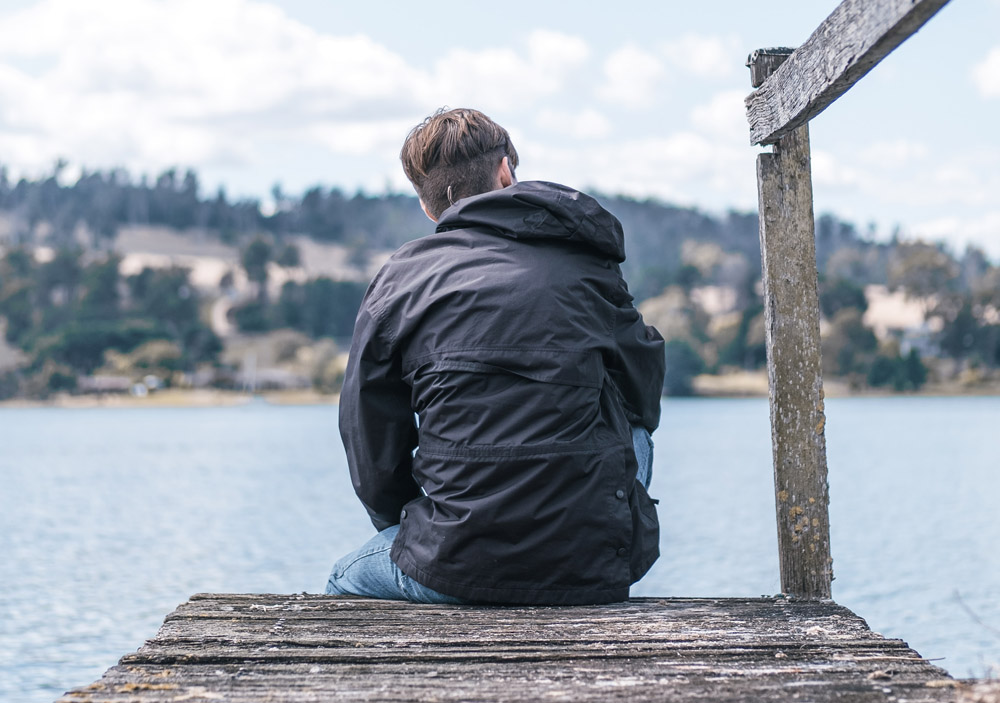 man sitting on dock